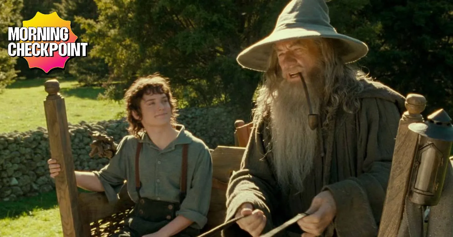 Gandalf and Frodo ride in a cart.